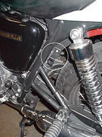 Accessory bracket mounted on front left side of rear fender